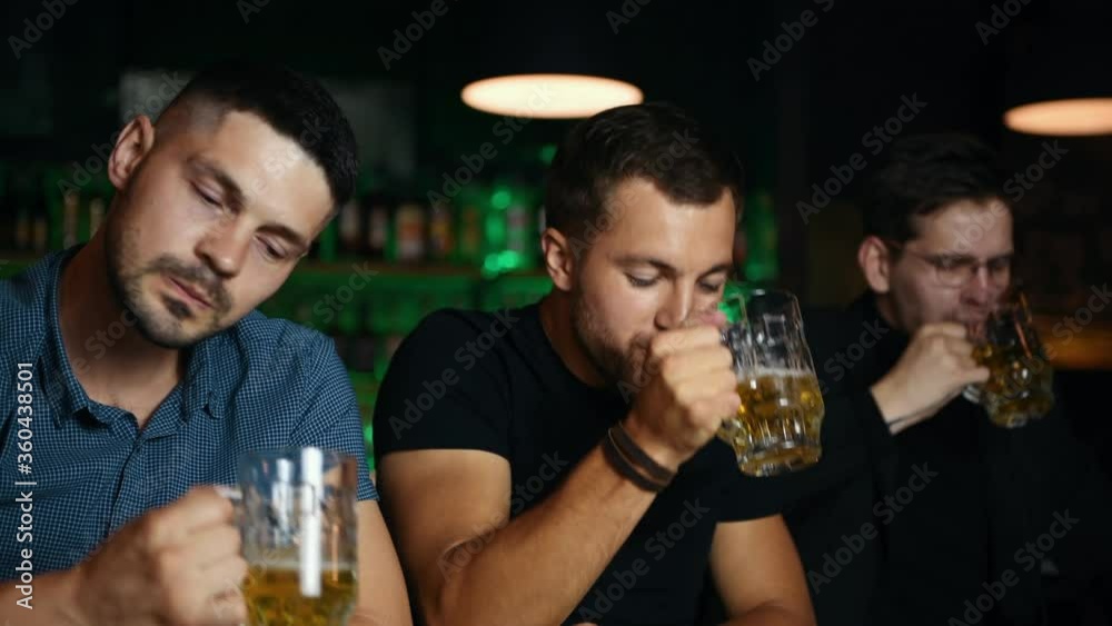 Three friends raise glasses with beer to the top. Celebrating victory. Three friends raise glasses with beer to the top. Celebrating victory.