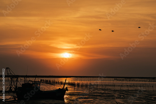 Sunset view with fisher man boat on sea surface.