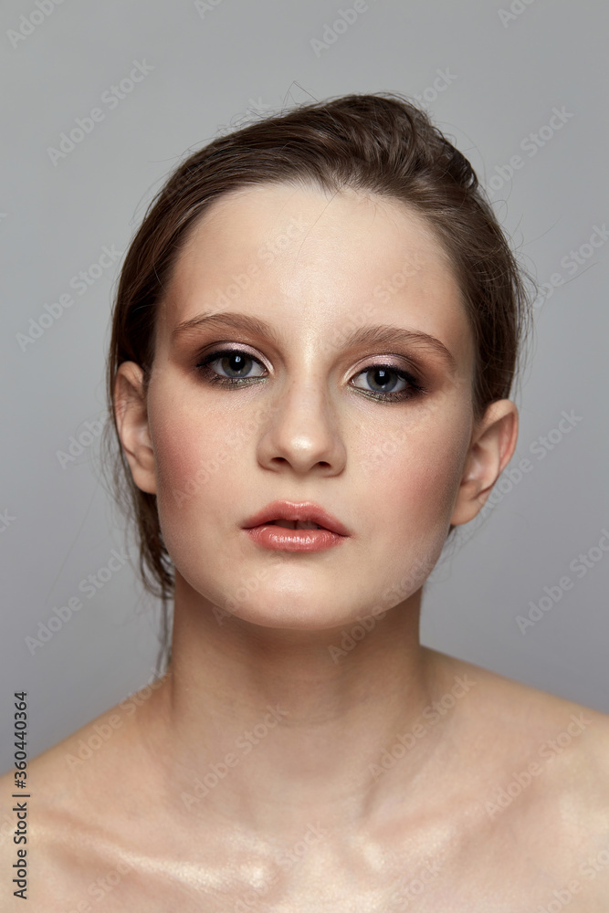 A beautiful brunette girl with bare shoulders looks into the camera. A beautiful brunette girl with bare shoulders looks into the camera.