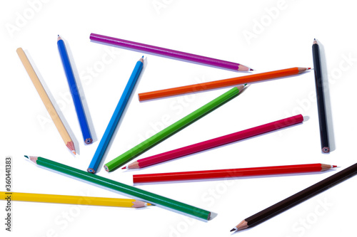 Colored pencils are randomly scattered on a white isolated background. © Vladimir