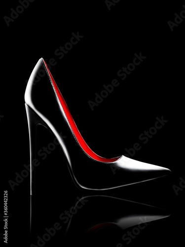 Valokuva Closeup shot of a black elegant high heel shoe isolated on a black background