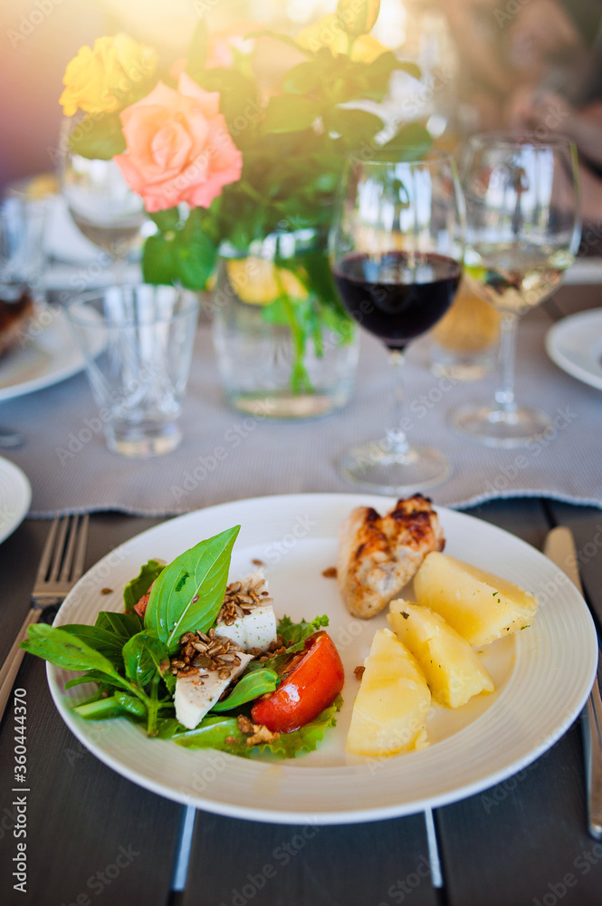 Plate with food on the table with flowers. Plate with food on the table with flowers.