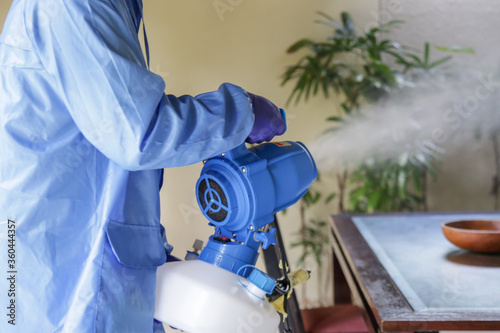 Cleaning and disinfecting: Key weapons in the fight against contagious diseases. Spray disinfection of surfaces in the house. Fogging with disinfectant due to coronavirus. photo