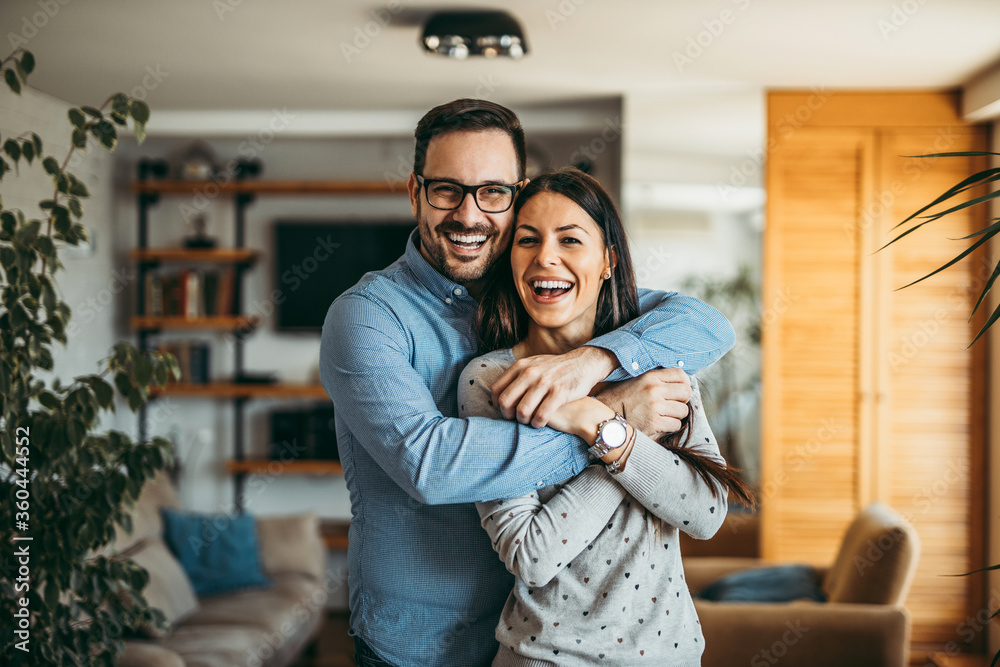 Fototapeta premium Portrait of a happy husband and wife hugging and smiling at camera.