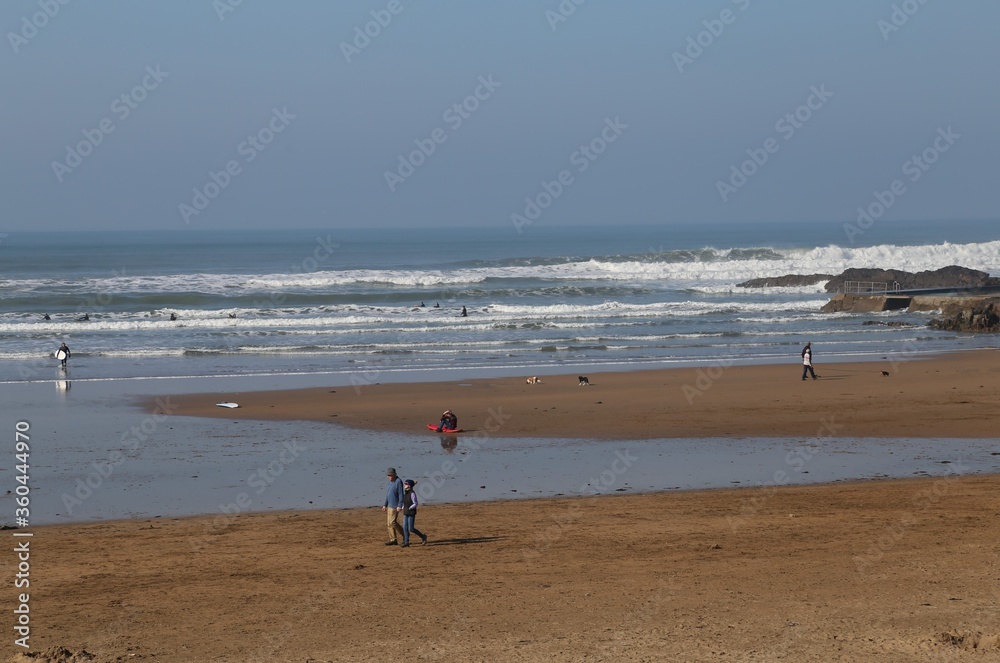 People enjoying the beach at Bude, Cornwall on a warm Winter's day. 