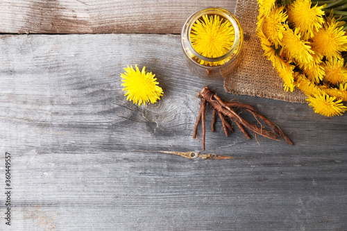 Dandelion broth in a glass jar on  vintage wooden background with copy space, medicinal herbs, herbal medicine, traditional medicine, natural cosmetics, herbalism concept. photo