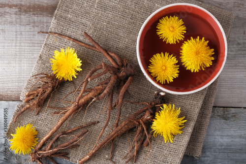 Decoction of flowers and dandelion roots on a vintage wooden background with copy space, medicinal herbs, herbal medicine, traditional medicine, natural cosmetics, herbalism photo