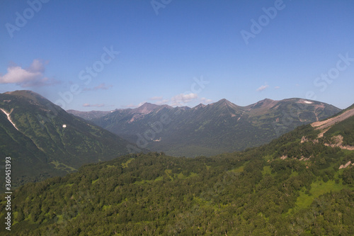 Daytime view in clear sunny weather of hills, rivers, mountains, forests, mountainous terrain. © Aleksandr