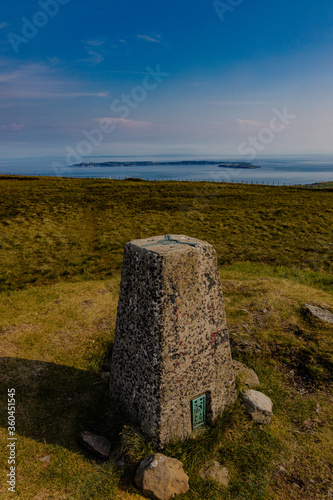 Knocklayd mountain summit cairn and trig pillar with a view to Rathlin Island, Ballycastle, Causeway coast and glens, County Antrim, Northern Ireland, Area of Outstanding Natural Beauty