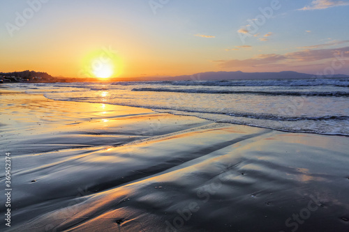 Unbelievable sunrise. Beautiful summertime view seascape. The wet sand on the sea coast. Morning landscape. High waves with foam. Widescreen frame backdrop. Location place island Crete, Greece.