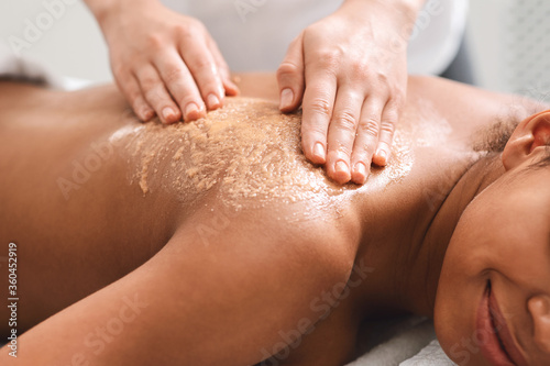 Closeup of black girl having skin peeling massage at spa photo