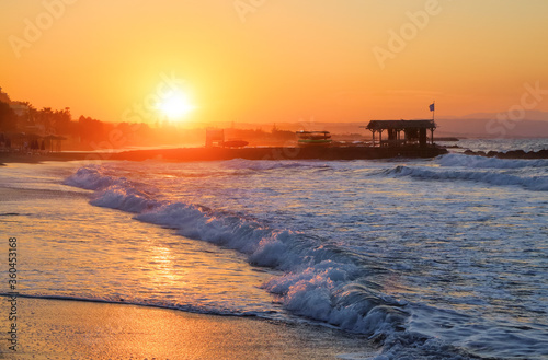 Beautiful summertime view seascape. The wet sand on the sea coast. Unbelievable sunrise. Morning landscape. High waves with foam. Romantic relax places. Location place island Crete, Greece.
