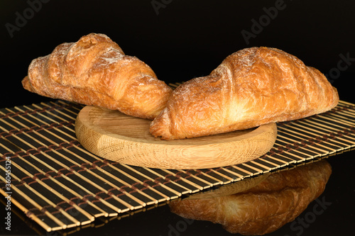 Homemade croissants, close-up, on a black background.