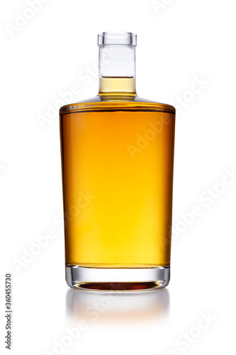 A full angular shaped bottle of golden whisky, with no label or branding, isolated on white