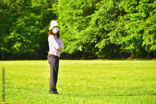 芝の上で立つ自然体の女性 02 © 良輔 武尾
