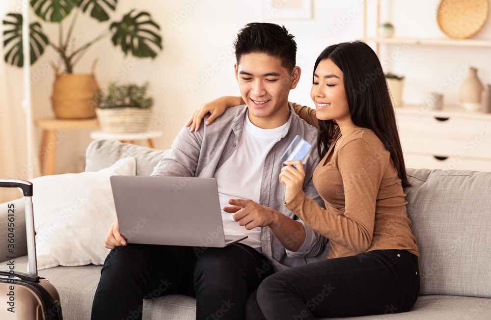 Happy Couple Using Laptop And Credit Card Sitting At Home