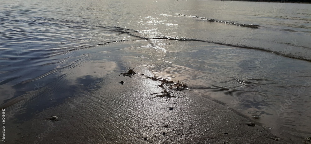 The sun shines beautifully on the sand surrounded on both sides by the sea The sun shines beautifully on the sand surrounded on both sides by the sea