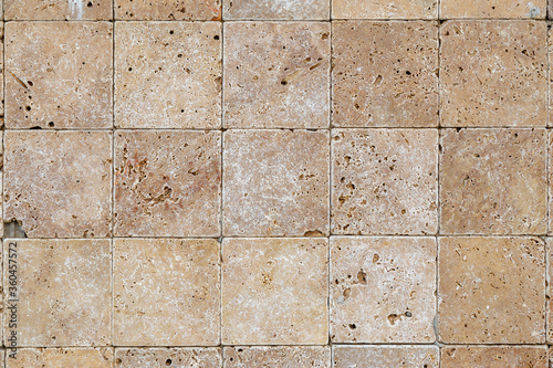 Wall background with Yellow natural sandstone tiles stiched together with clay