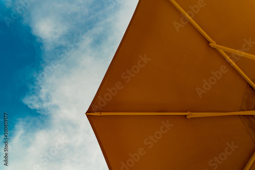 Looking up to the sky and orange sun umbrella