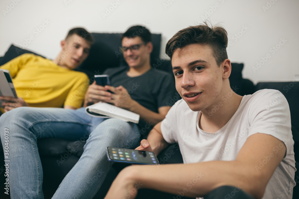 teenager boys using mobile phones at home teenager boys using mobile phones at home
