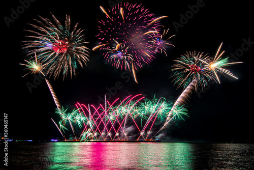 Amazing beautiful colorful fireworks display on celebration night, showing on the sea beach with multi color of reflection on water	 photo