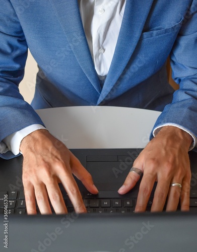 Young businessman sitting in front of the computer, telecommuting from home