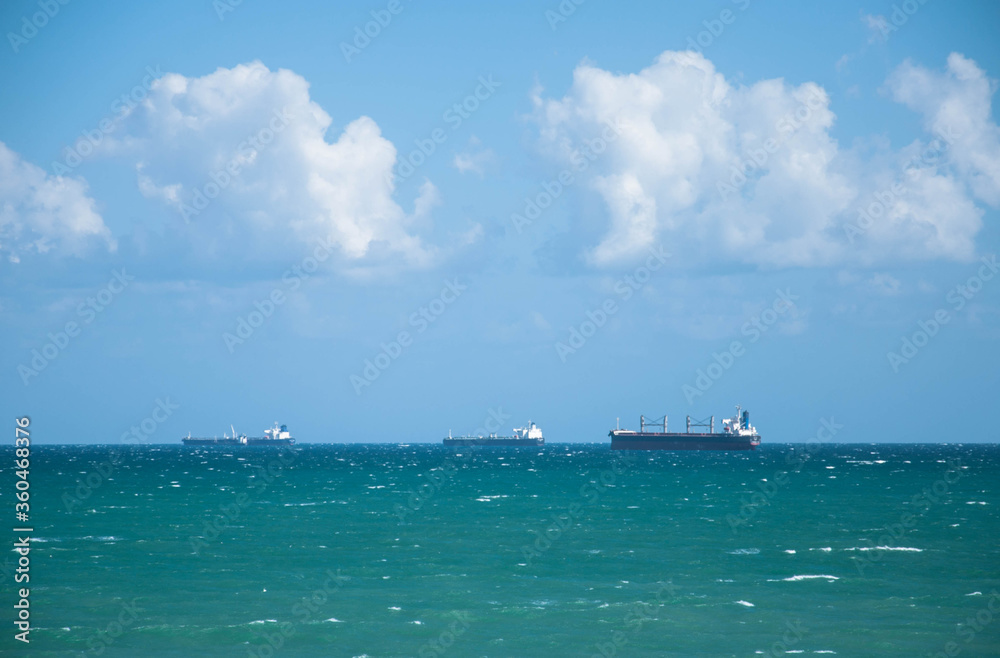 Ships on the horizon of the sea on a background of blue sky