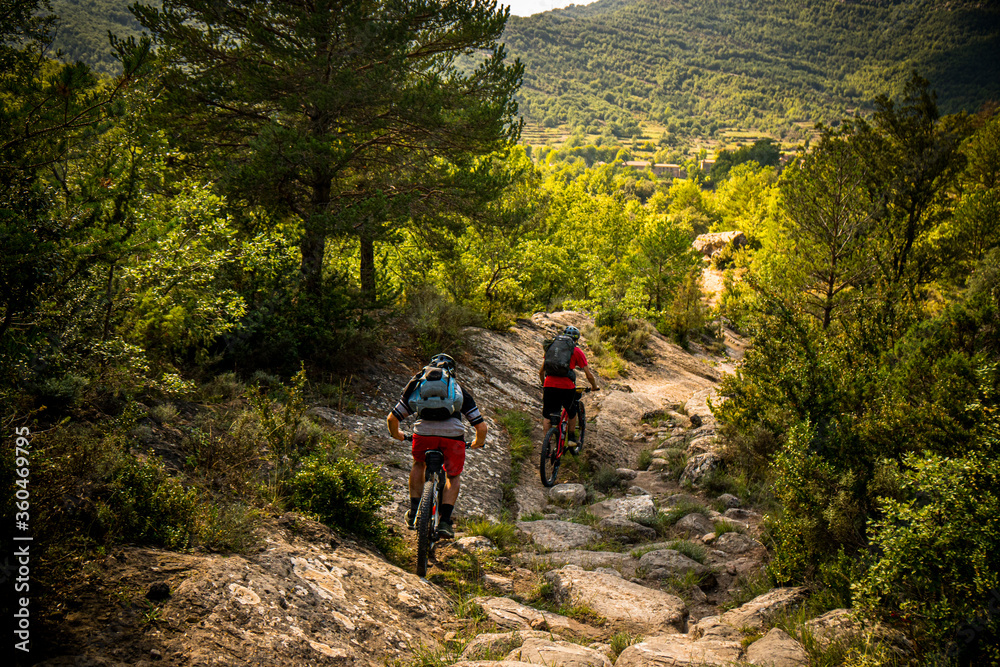 Two mountain bikers riding a dry river bend near Nocito in the Spanish Pyrenees Two mountain bikers riding a dry river bend near Nocito in the Spanish Pyrenees