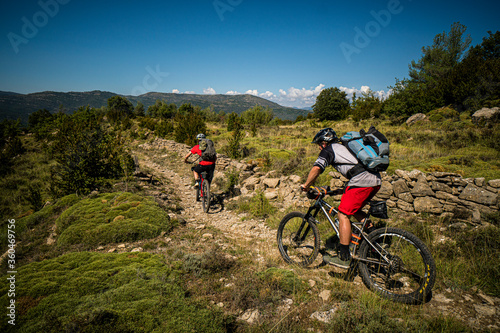 Two mountain bikers on a rocky path in the low Pyrenees. Huesca, Spain.