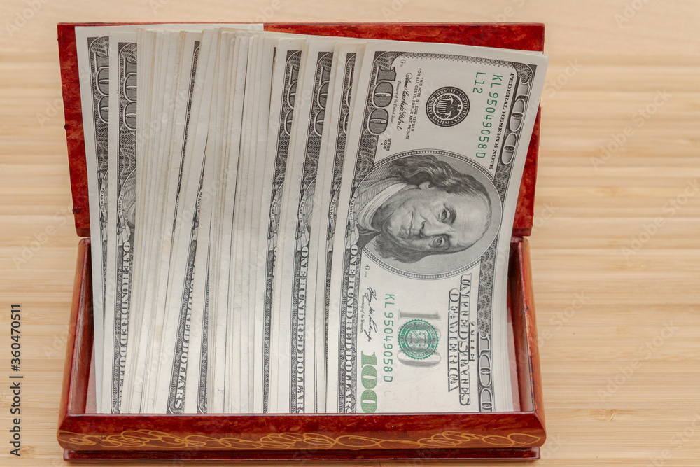 American hundred dollar bills in large quantities in a wooden box American hundred dollar bills in large quantities in a wooden box