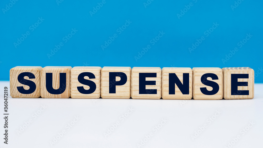 concept word SUSPENSE on cubes on a blue background concept word SUSPENSE on cubes on a blue background