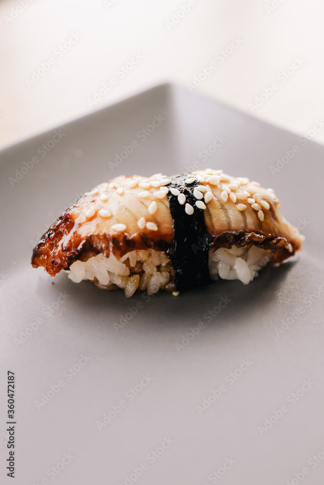 One beautiful gukan lying on a grey plate sprinkled with sesame seeds One beautiful gukan lying on a grey plate sprinkled with sesame seeds