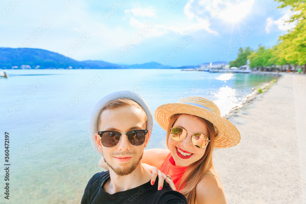 Young happy couple in mountain lake making selfie photo. a guy w Young happy couple in mountain lake making selfie photo. a guy w