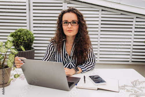 Beautiful smart cute adorable attractive elegant owner of a large company has an online meeting with international business partners, she sits at a desk in the workplace