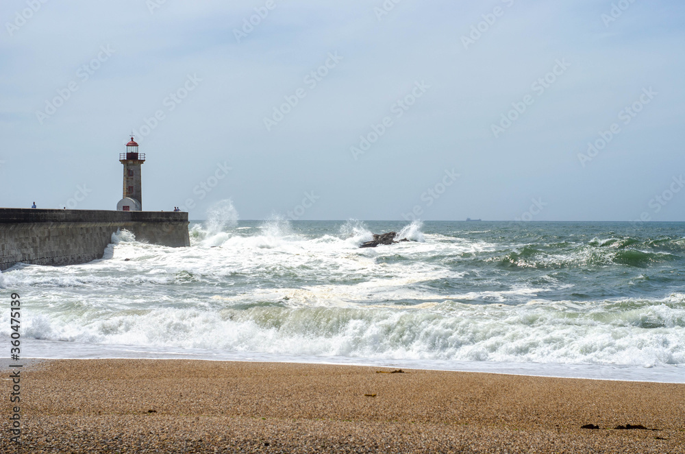 Lighthouse on a Porto city Portugal beach with dramatic waves of atlantic ocean