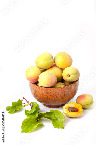 Fresh ripe apricots in wooden bowl isolated on a white background.