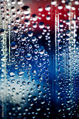 Defocused American flag is refracted in drops of water on the glass. The focus of the photo is on the stars reflected in the drops. © Mila.LifeReporters