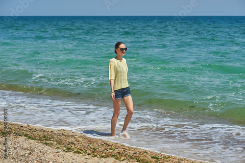 A young thin woman walks on the seashore © fisher05