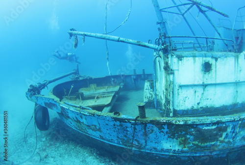 Scuba Divers Exploring underwater ship wreck 