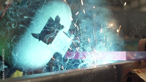 worker welding steel with mig welder machine slow motion photo
