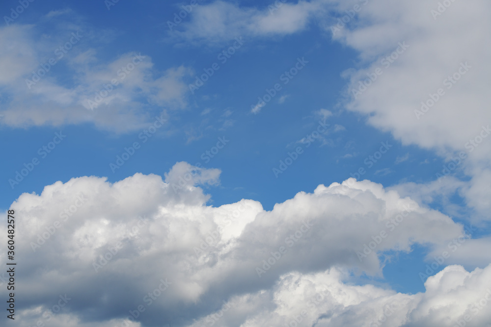 Layered summer clouds against a bright blue sky Layered summer clouds against a bright blue sky