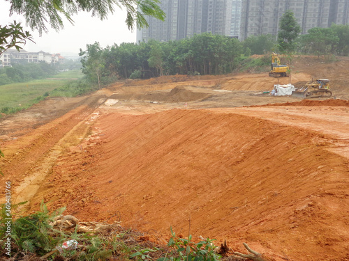 Photography KUALA LUMPUR, MALAYSIA -JULY 17, 2019: Heavy machinery doing the soil backfilling work at the construction site