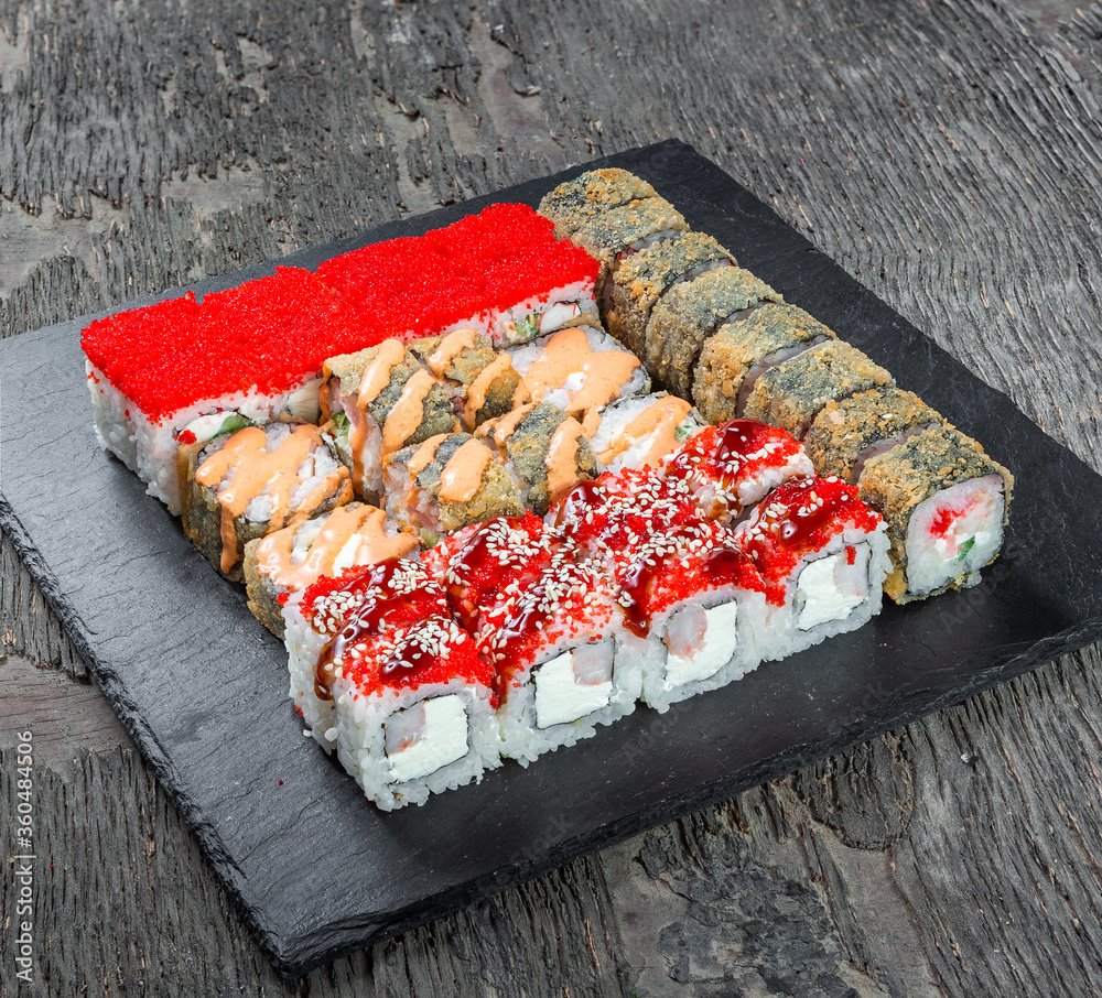 Japanese cuisine. Seafood, vegetables and meat. Sushi and rolls big set isolation on a wooden table background