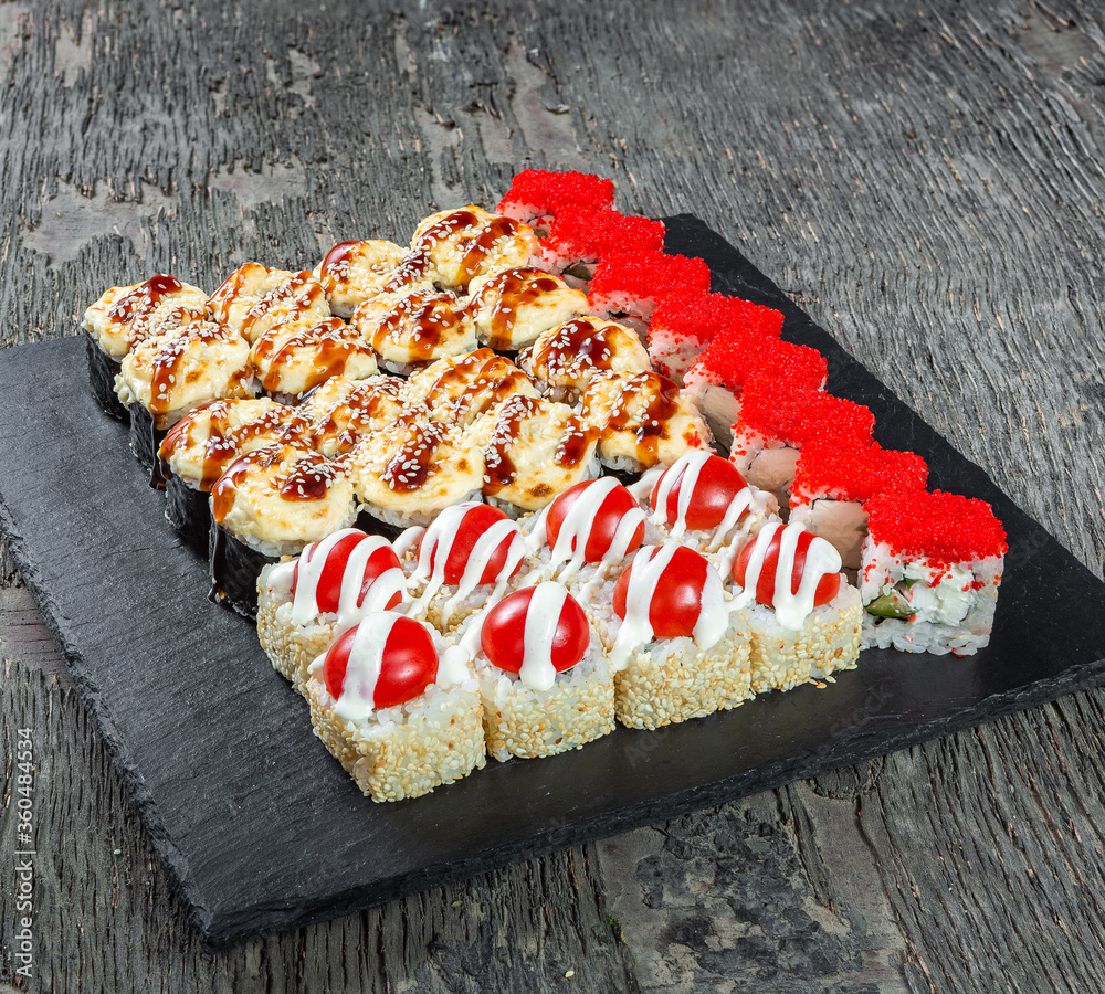 Japanese cuisine. Seafood, vegetables and meat. Sushi and rolls big set isolation on a wooden table background