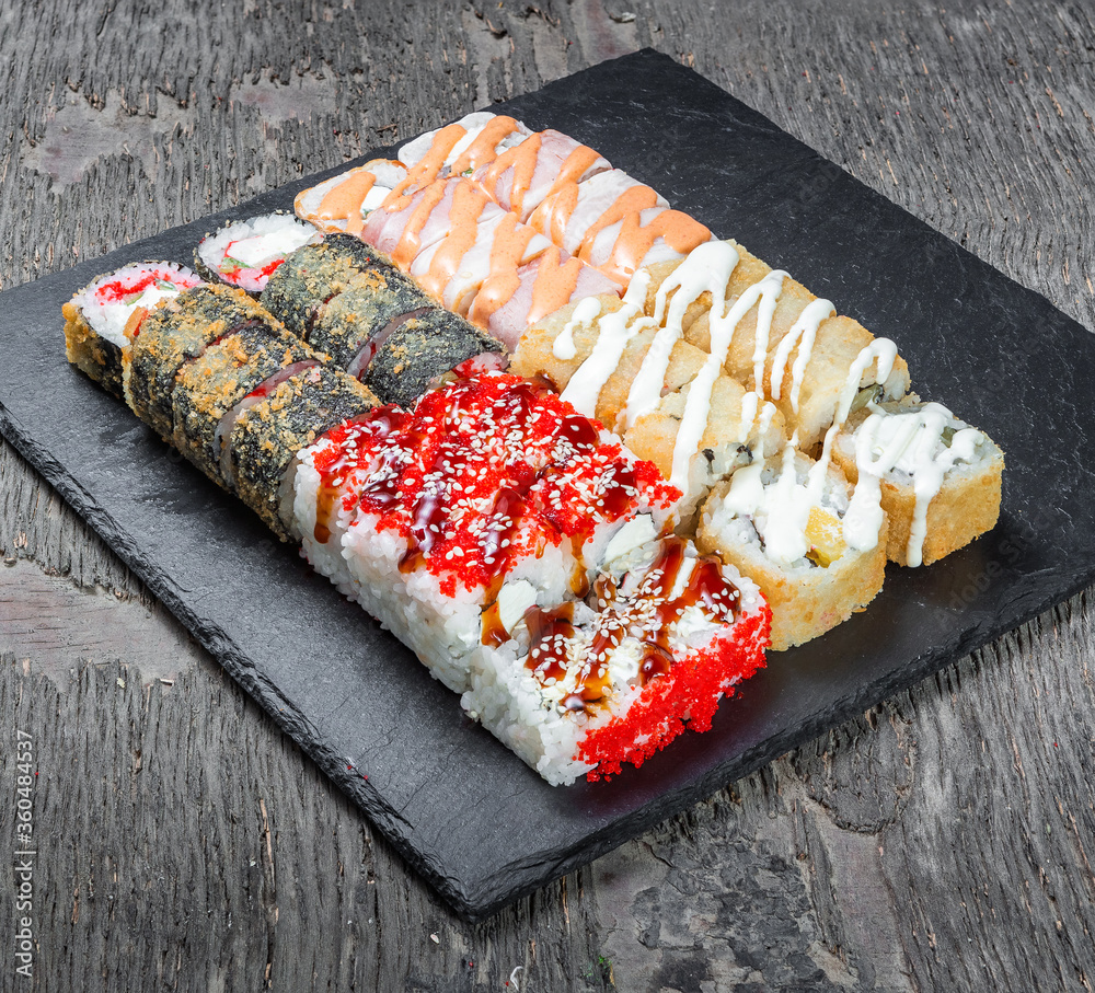 Japanese cuisine. Seafood, vegetables and meat. Sushi and rolls big set isolation on a wooden table background
