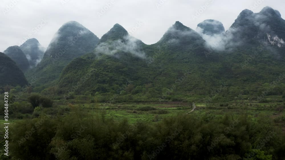 Chinese rural countryside with karst mountains in background, camera tilt reveal Chinese rural countryside with karst mountains in background, camera tilt reveal