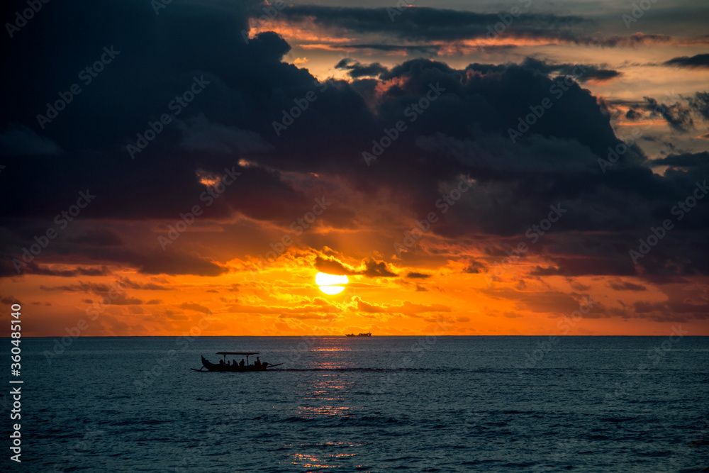 Boat in the ocean at sunset and bright sky