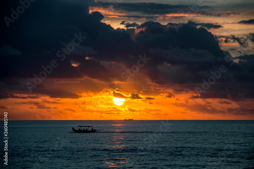 Boat in the ocean at sunset and bright sky