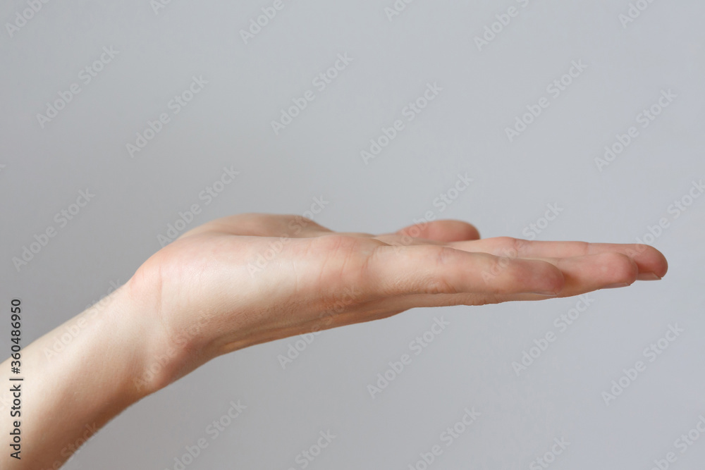 Gesture and sign, male hand holds something on a light background Gesture and sign, male hand holds something on a light background