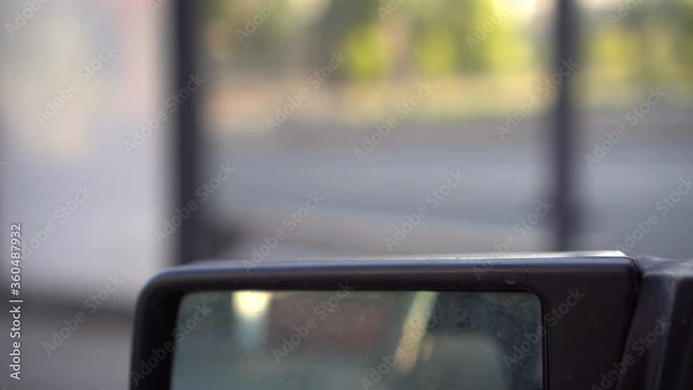 A man put fried potatoes on a car mirror. Sparrow took the potatoes. A man put fried potatoes on a car mirror. Sparrow took the potatoes.